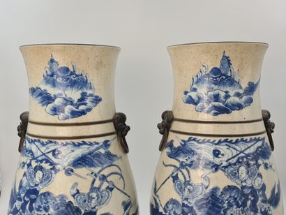 null 一对南京瓷器花瓶，米色裂纹背景上有蓝色的马术比赛装饰。狮子面具的手柄。中国 19世纪。底座下有工场标记。高度：52厘米。棕色珐琅的边缘有一个细小的缺口...