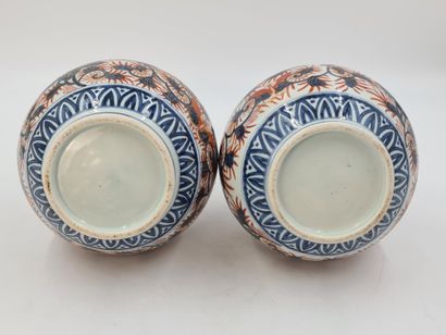 null A pair of Imari porcelain bottle vases with rounded sides and long necks, decorated...