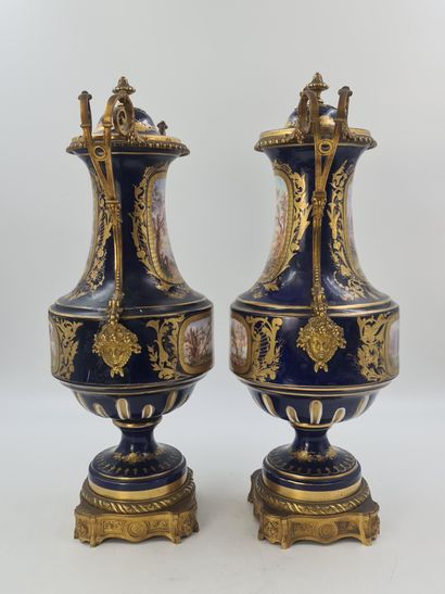 null 一对19世纪末塞夫勒风格的瓷器花瓶，蓝色和金色背景上有浪漫的储备装饰。鎏金铜的美丽装饰品。一个花瓶损坏。高度：51厘米。

一对来自19世纪末的塞夫勒...