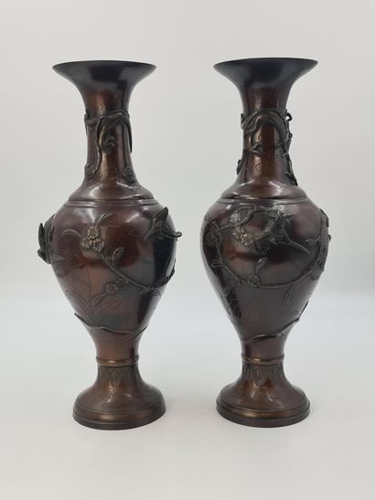 null A pair of large bronze vases with long necks and curved sides on high flared...