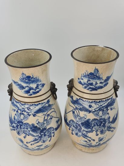 null 一对南京瓷器花瓶，米色裂纹背景上有蓝色的马术比赛装饰。狮子面具的手柄。中国 19世纪。底座下有工场标记。高度：52厘米。棕色珐琅的边缘有一个细小的缺口...
