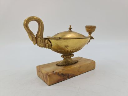 null 一个以狮子头为结尾的古董油灯形状的桌面烛台。查理十世时期的鎏金青铜器。锡耶纳大理石底座。高度：10厘米。宽度：19厘米。

在一个古老的村庄里，有一盏...