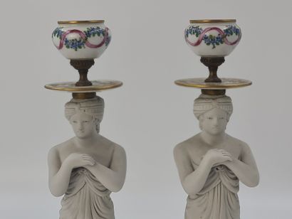 null Pair of porcelain and white cookie candlesticks representing oriental women...