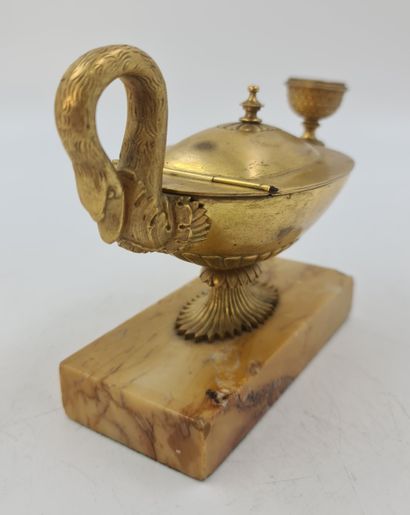null 一个以狮子头为结尾的古董油灯形状的桌面烛台。查理十世时期的鎏金青铜器。锡耶纳大理石底座。高度：10厘米。宽度：19厘米。

在一个古老的村庄里，有一盏...