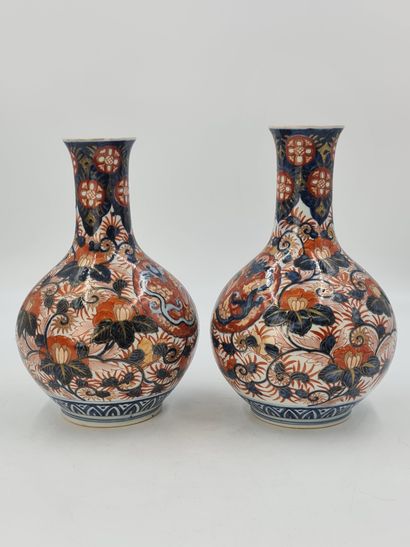 null A pair of Imari porcelain bottle vases with rounded sides and long necks, decorated...