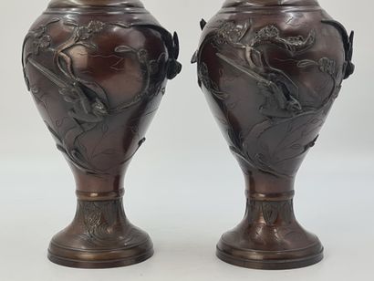null A pair of large bronze vases with long necks and curved sides on high flared...