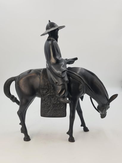 null Sujet en bronze à patine brune, représentant Toba sur sa mule, coiffé d’un grand...