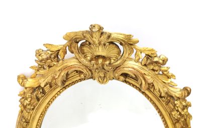 null Medallion mirror in carved wood and gilded stucco with a frieze of pearls and...