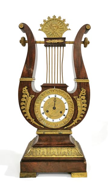 null *Mahogany burl veneer lyre clock; the set of simulated horns surmounting a mascaron...
