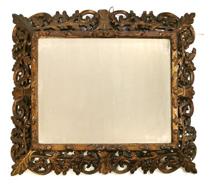 null *Grand miroir, le cadre à profil inversé en bois sculpté et doré à décor ajouré...