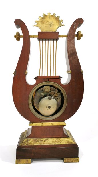 null *Mahogany burl veneer lyre clock; the set of simulated horns surmounting a mascaron...