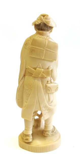 null *Japan, 1880

Carved ivory okimono showing a standing peasant carrying a bag...