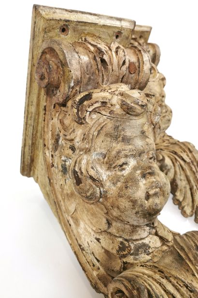 null A pair of carved and cream lacquered wood brackets in the form of cherubs' heads...