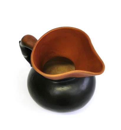 null Earthenware pitcher with black and ochre/red glaze, the spout strongly pronounced,...