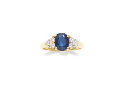 null 18K (750 thousandths) yellow gold ring set with an oval faceted sapphire weighing...