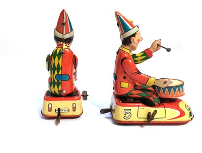 null Pair of mechanical toys representing clowns drumming in their mechanical cars,...