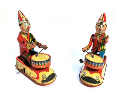 null Pair of mechanical toys representing clowns drumming in their mechanical cars,...