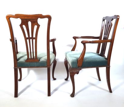 null A pair of carved wooden armchairs, the arms arched, the back openwork with a...
