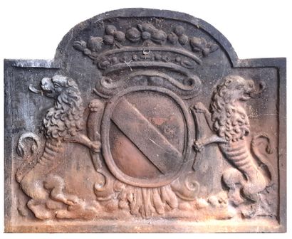 null Cast iron fireback decorated with two lions facing each other framing a coat...