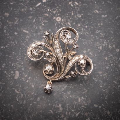 null Broche en or jaune 18K (750 millièmes) et argent à décor de volutes sertie de...