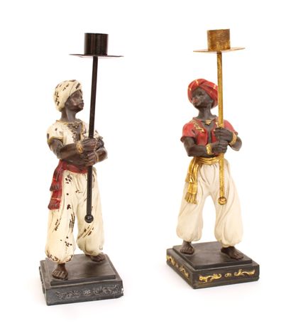 null Pair of candlesticks in metal and polymer, the shafts representing Nubians carrying...