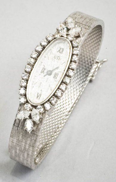 MELLERIO Bracelet montre de dame en or gris satiné de forme ovale, la lunette sertie...