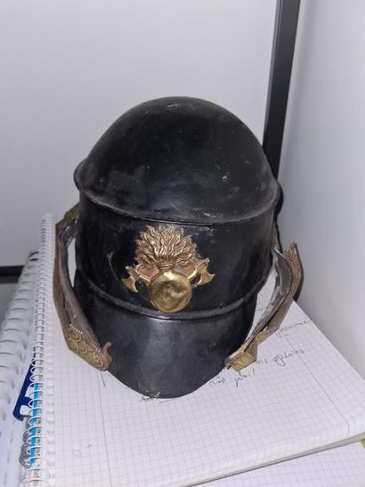 null Firefighter's helmet XIXth century in painted iron sheet, plate with two axes...