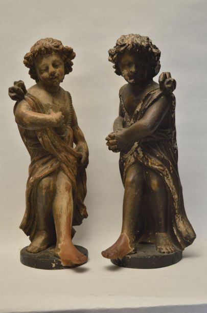 null Pair of wooden cherubs with polychromy remains, one with a sooty patina and...