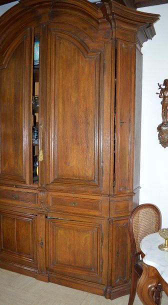 null Importante armoire en bois naturel mouluré et sculpté, ouvrant par deux vantaux...