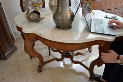 null Moulded and carved wooden middle table, opening with two drawers and resting...