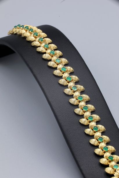 null 
18K yellow gold bracelet with barley grain decoration set with 21 green stone...