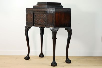 null 
Carved mahogany cabinet decorated with interlacing friezes and palmettes resting...