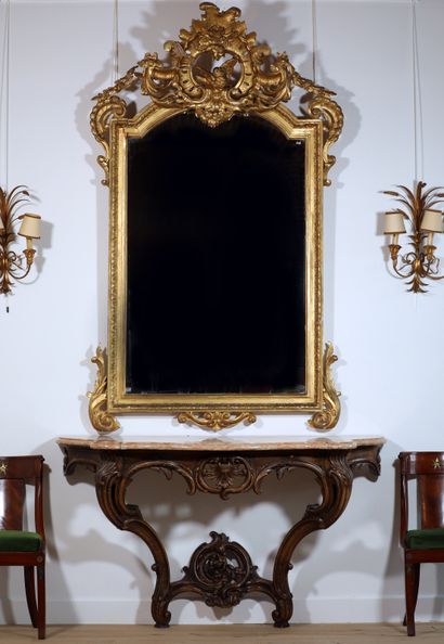 null 
Grand miroir en bois doré à décor de frise de feuillage. Grand fronton à décor...