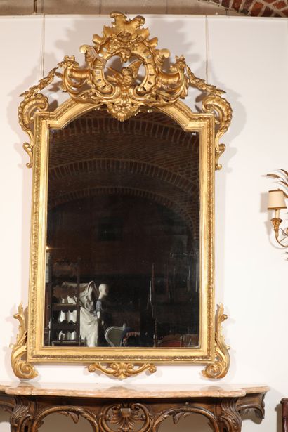 null 
Grand miroir en bois doré à décor de frise de feuillage. Grand fronton à décor...