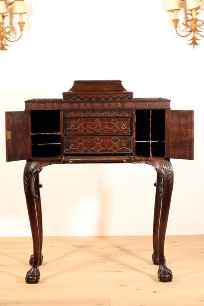 null 
Carved mahogany cabinet decorated with interlacing friezes and palmettes resting...