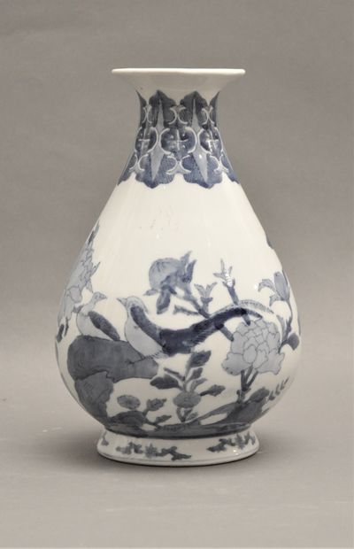 null Vase en porcelaine blanc-bleu à décor de fleurs de pivoine et faisans. Travail...