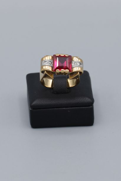 null 18K yellow gold tank ring, set with a square-cut red stone and flanked by two...
