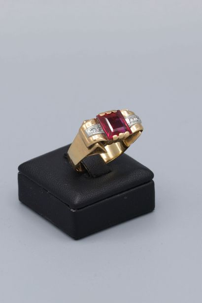 null 18K yellow gold tank ring, set with a square-cut red stone and flanked by two...