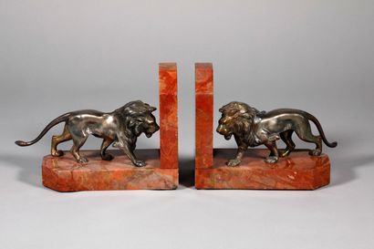 null A pair of patinated silver bronze bookends with lions on a red marble base....
