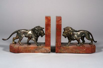 null A pair of patinated silver bronze bookends with lions on a red marble base....