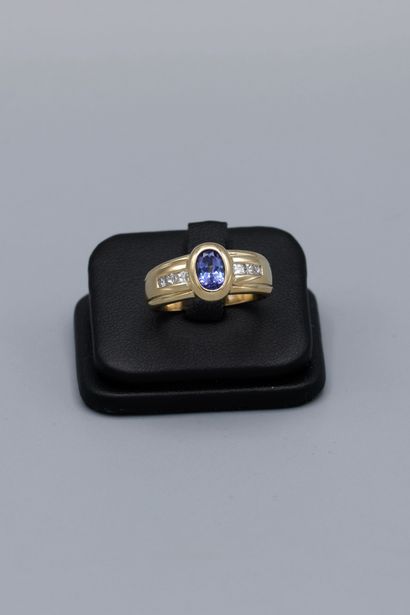 null 14K yellow gold ring, set with an oval sapphire flanked by six princess-cut...