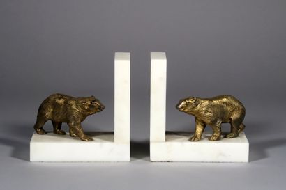 null A pair of ormolu bookends with a patinated bear design on a white marble base....