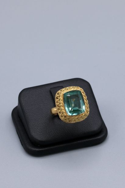 null Yellow gold ring with basket weave design set with a light green emerald cut...