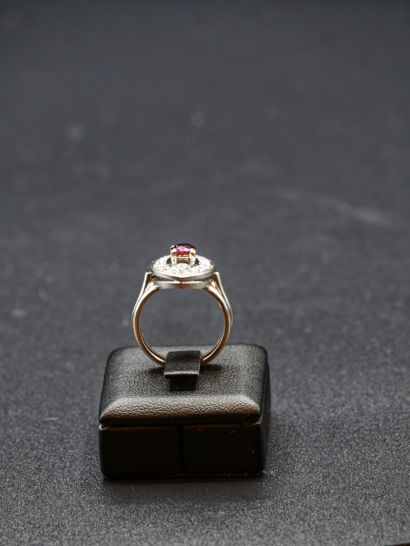 null 
Bague en or blanc de forme navette centrée d'une pierre rouge dans un entourage...