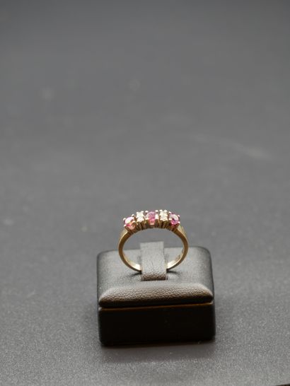 null 
Yellow gold ring set with three red stones interspersed with two small diamonds...