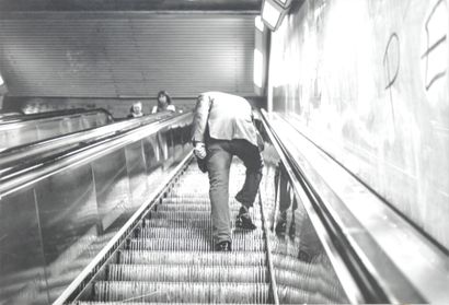 null Unidentified photographer. Going up an escalator in the subway (attr.). Black...
