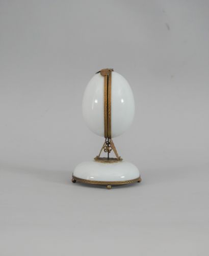 null Fabergé style egg-shaped perfume dispenser in white glass and brass, composed...
