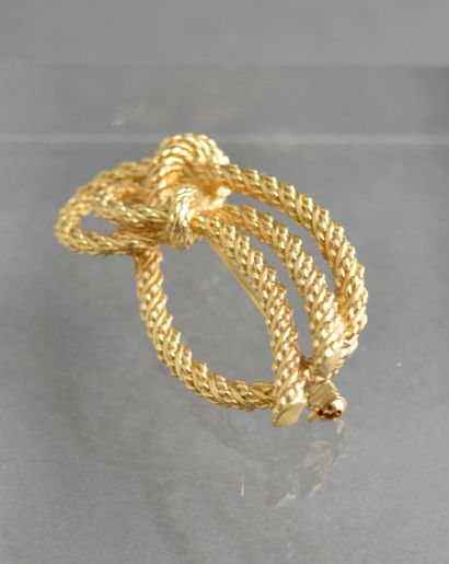 null MAISON DIOR. Broche nœud imitant la corde en métal doré. H : 5 cm.
