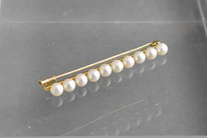 null BROCHE ligne en or jaune 18K à décor de 10 perles (5,5mm). Long : 6cm, Poids...