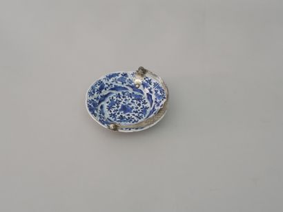 null CHINA, 17th century. Porcelain cup enamelled white blue with flowers and foliage...